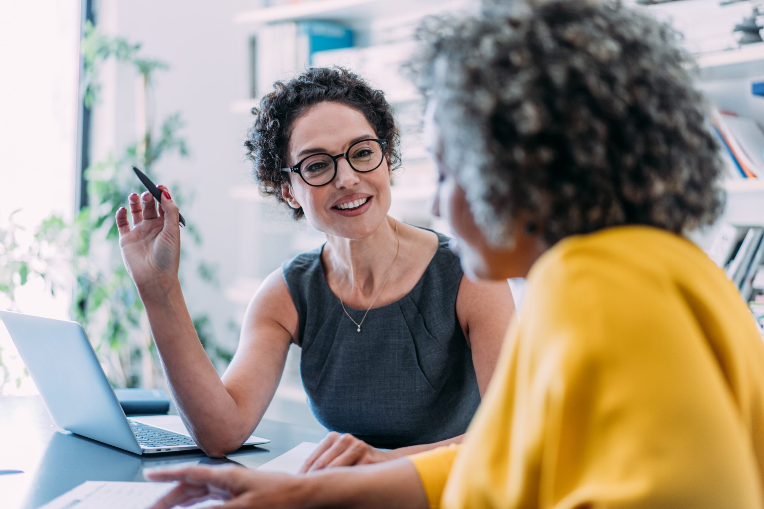Dos mujeres charlando en un espacio de trabajo. Concepto de cordialidad y negocios.