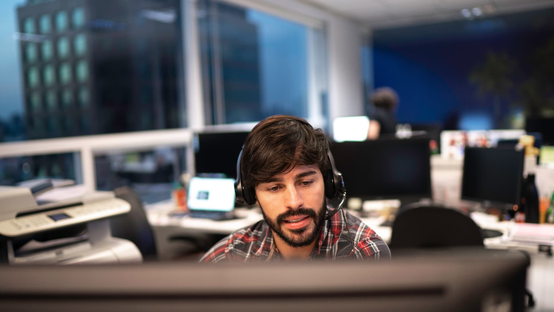 Hombre trabajando de agente atendiendo a clientes por teléfono.