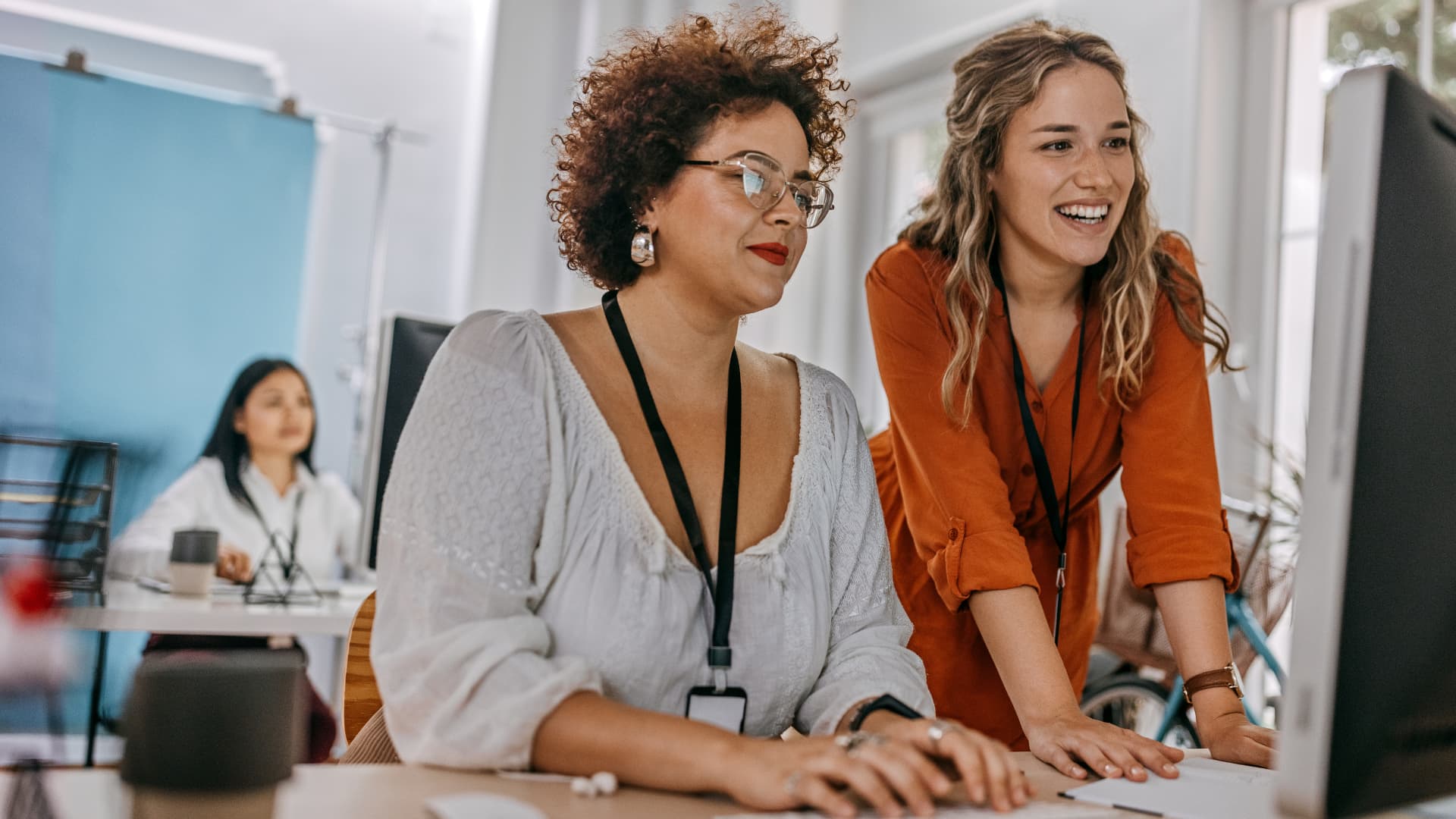 Dos mujeres trabajando en equipo en su oficina.