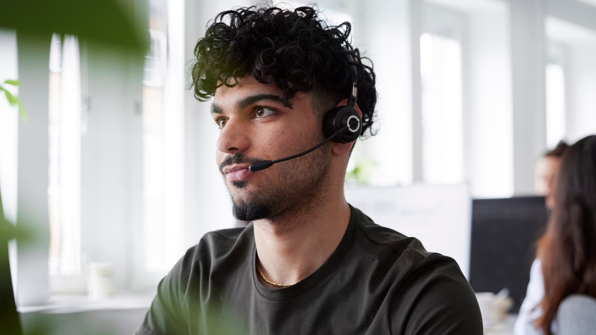 Chico joven trabajando en un Contact Center como agente de atención al cliente.