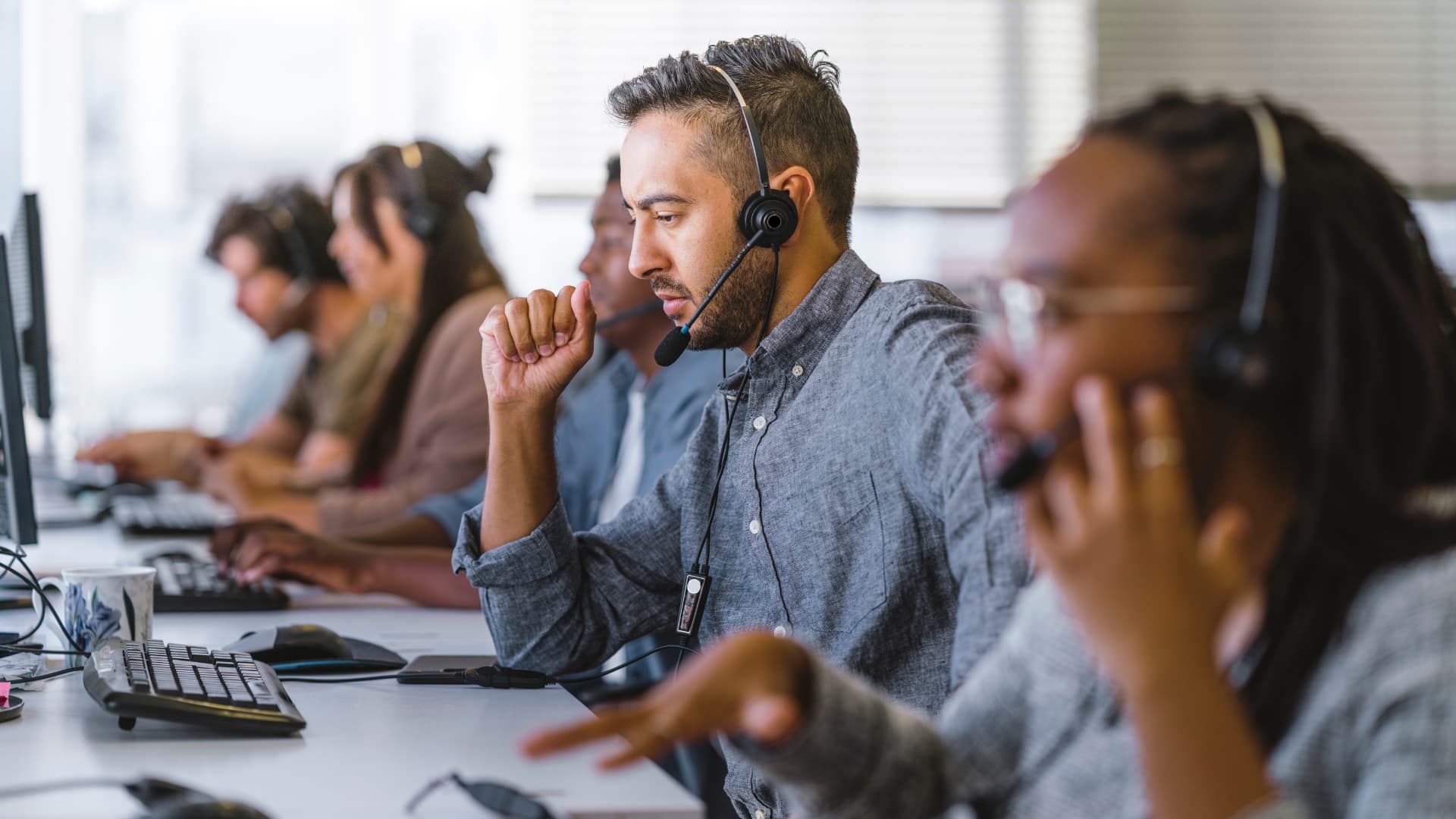 Trabajadores agentes atendiendo telefónicamente a los clientes en un call center.