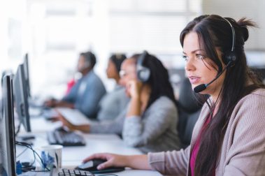Agentes en un centro de contact center atendiendo llamadas con auriculares para mejorar la contactabilidad.