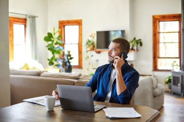 hombre-joven-teletrabajando-salon-casa-trabajo-hibrido