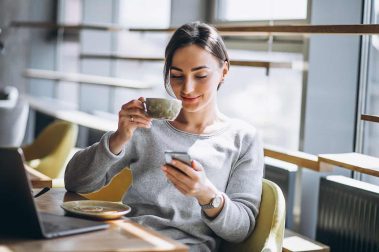 woman-sitting-in-cafe-drinking-coffee-and-working-on-computer_web