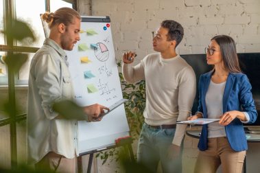 young-man-standing-by-flipchart-and-giving-present-2022-02-02-21-53-47-utc
